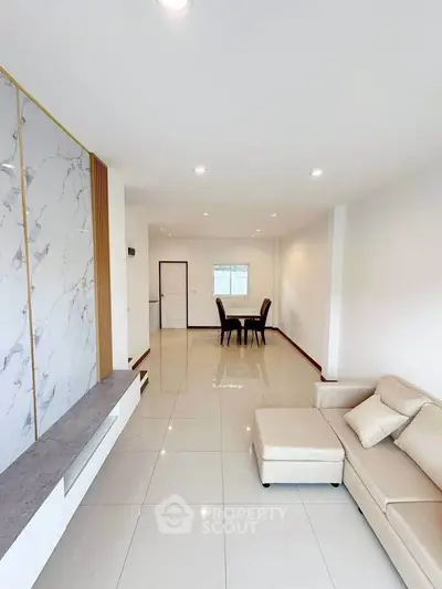 Spacious modern living room with elegant marble accents and cozy seating area.