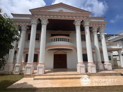 Majestic neoclassical mansion with grand columns and elegant facade under clear blue sky.