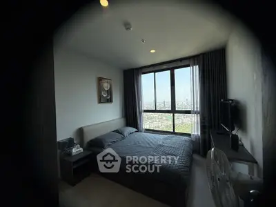 Modern bedroom with city view, featuring large window and stylish decor.