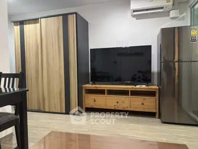 Modern living room with sleek furniture and appliances, featuring a TV and air conditioning.