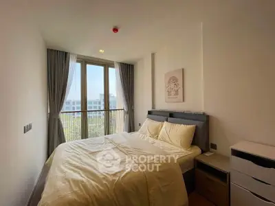 Cozy bedroom with large window and modern decor in a stylish apartment.
