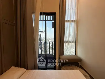 Cozy bedroom with balcony and city view, perfect for relaxation.