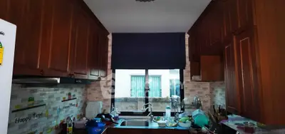 Charming kitchen with wooden cabinets and modern backsplash, featuring a cozy window view.