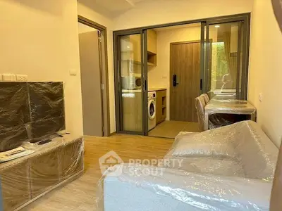 Modern living room with sliding glass doors and washing machine in cozy apartment.