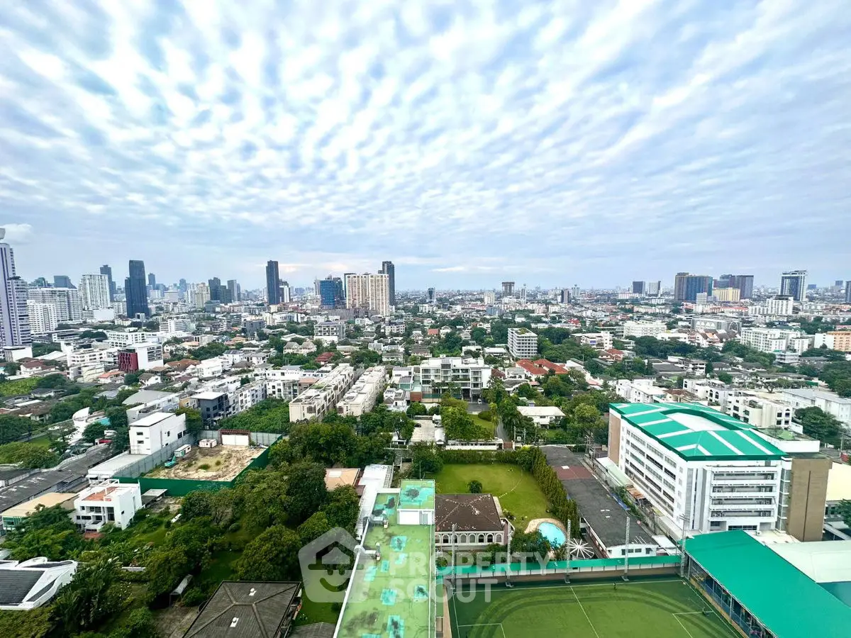 Stunning cityscape view from high-rise building showcasing urban skyline and greenery.