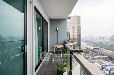 Modern high-rise balcony with stunning city view and sleek glass railing.