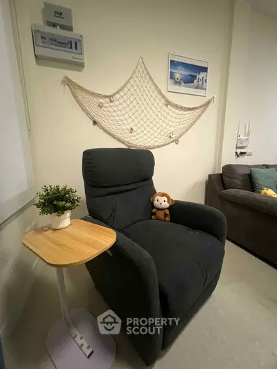 Cozy living room corner with plush armchair and decorative wall art
