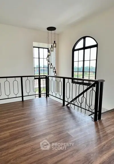 Elegant interior space with wooden flooring and stylish lighting, featuring large windows for natural light.