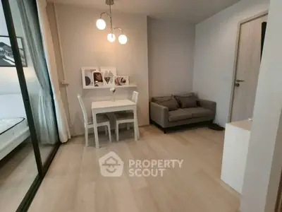 Modern living room with cozy sofa and dining area, featuring elegant lighting and stylish decor.