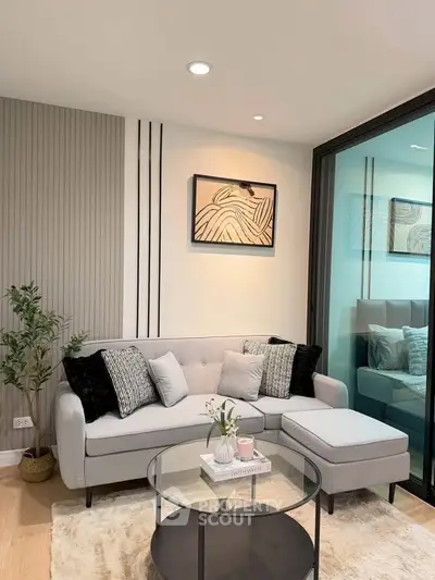 Stylish modern living room with cozy sofa, elegant decor, and glass coffee table in a chic apartment.