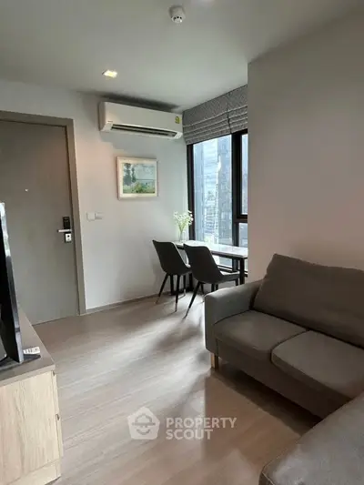 Modern living room with sleek furniture and large window offering city view