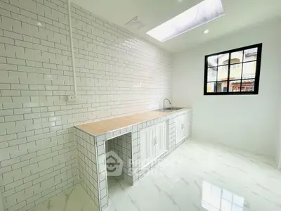 Bright modern kitchen with sleek white tiles and natural light