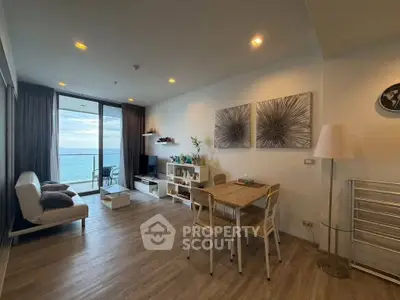Modern living room with ocean view, stylish decor, and natural light in a high-rise apartment.
