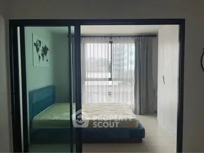 Modern bedroom with large windows and sleek furnishings in a stylish apartment.