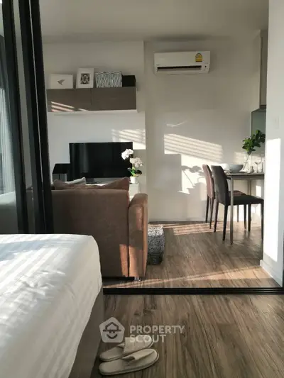 Modern studio apartment with open layout, featuring cozy living area and dining space, ideal for urban living.