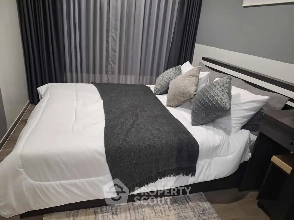 Modern bedroom with stylish decor and cozy bedding in a contemporary apartment.