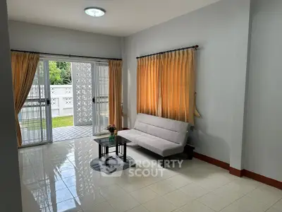 Bright living room with modern sofa and garden view, perfect for relaxation.