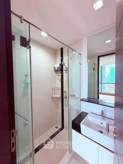 Modern bathroom with glass shower and sleek sink in urban apartment
