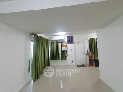 Spacious living room with green curtains and glossy tiled floor