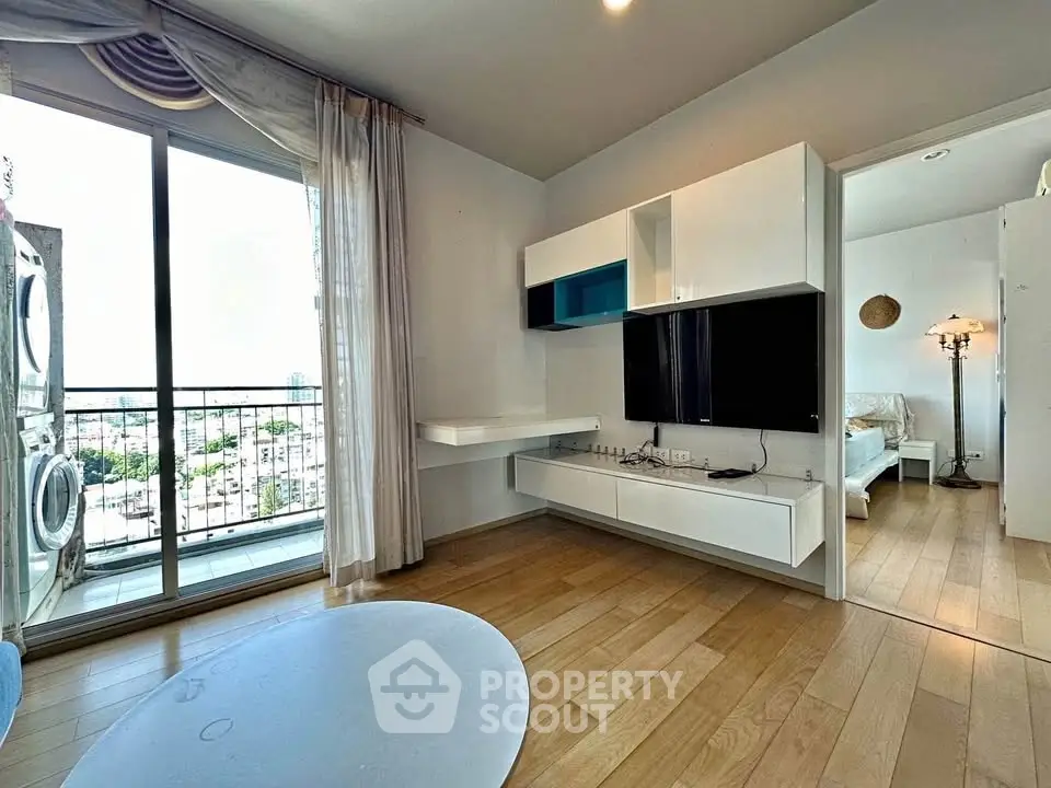 Modern living room with wooden flooring and balcony view in a stylish apartment