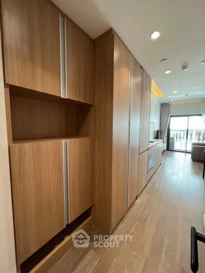 Modern open-layout kitchen with sleek wooden cabinetry and bright natural light.