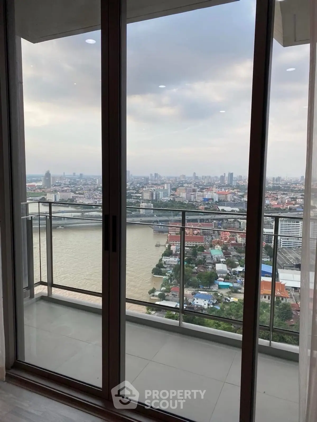 Stunning high-rise balcony view overlooking a river and cityscape, perfect for urban living.