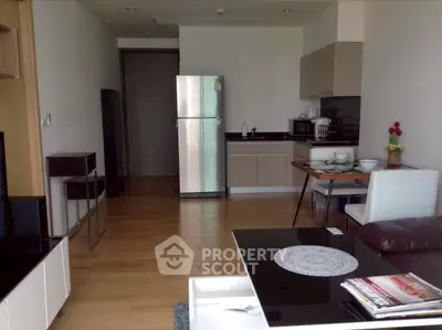 Modern open-plan living room with sleek kitchen and stainless steel fridge, perfect for urban living.