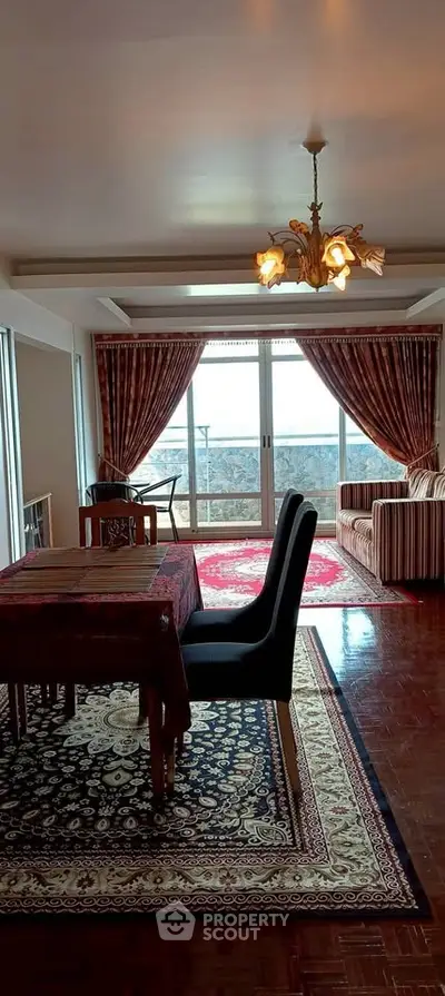 Elegant living room with large windows and stylish decor, featuring a cozy seating area and dining space.