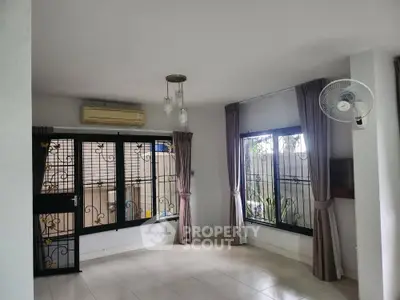 Spacious living room with large windows and modern lighting in a serene home setting.