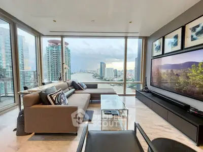 Luxurious living room with stunning city and river views, modern decor, and floor-to-ceiling windows.