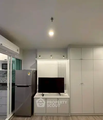 Modern living room with sleek TV unit and spacious wardrobe in a stylish apartment.