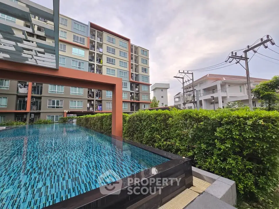 Modern apartment building with a stylish pool and lush greenery, offering a serene urban living experience.