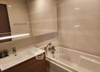 Modern bathroom with sleek design featuring bathtub and stylish sink.