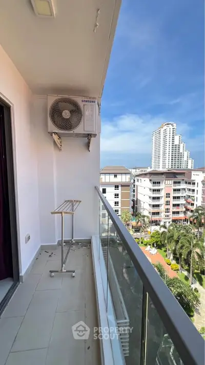 Modern balcony with city view and air conditioning unit in high-rise apartment