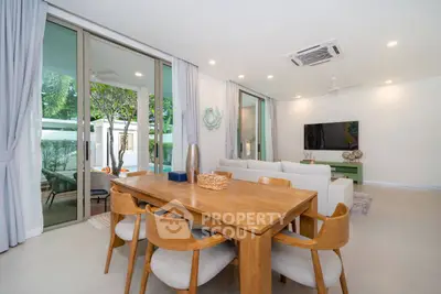 Spacious modern living room with elegant dining area and large sliding glass doors to patio.