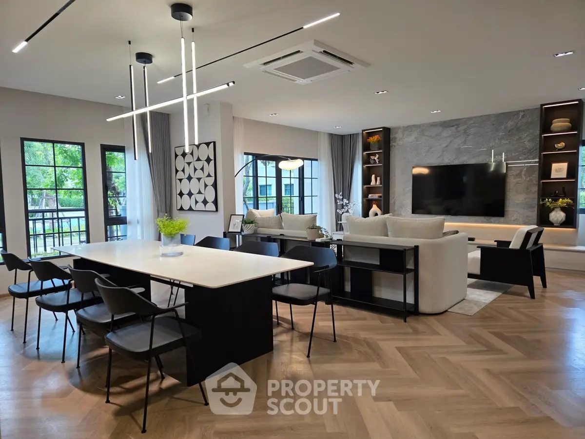 Luxurious open-plan living and dining area with modern decor and large windows.