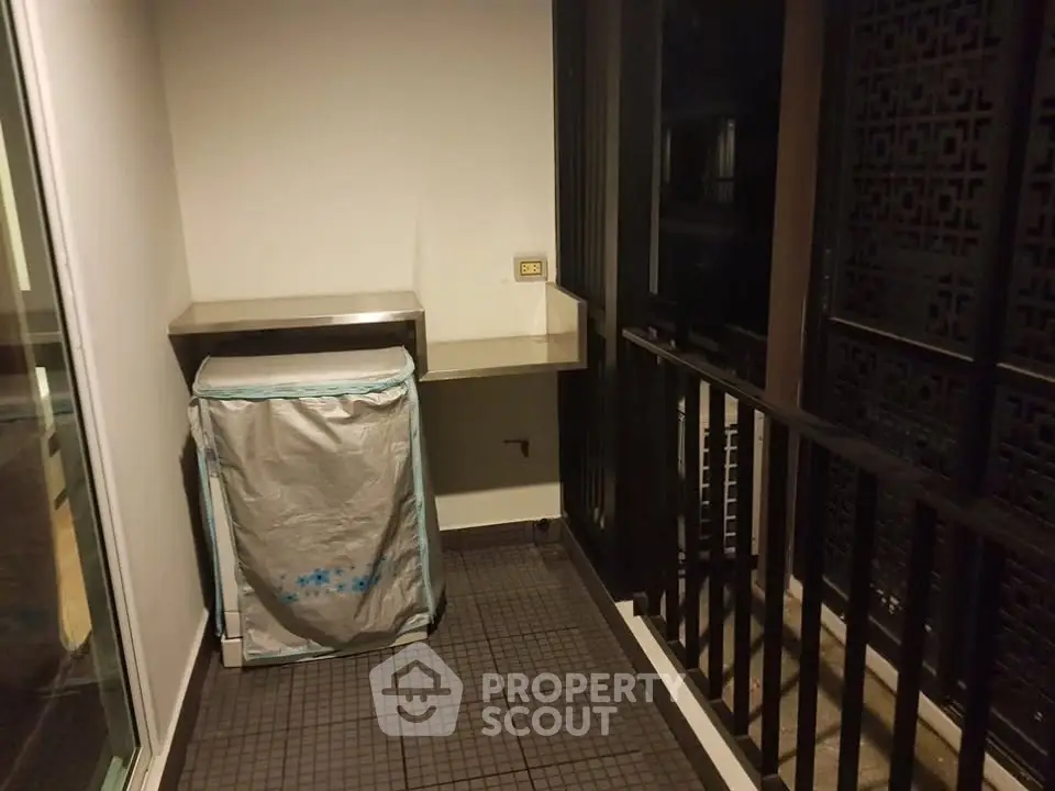Compact balcony with washing machine and metal countertop, ideal for urban living.