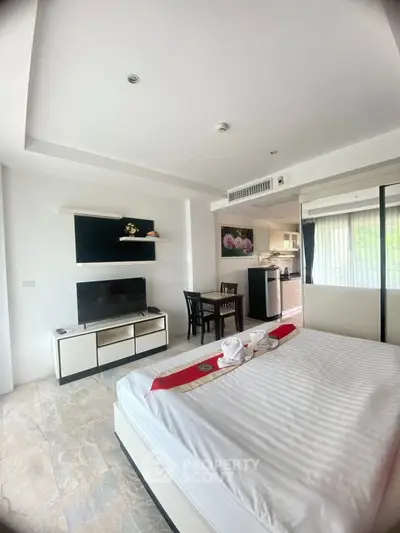 Modern bedroom with TV and kitchenette in open layout studio apartment