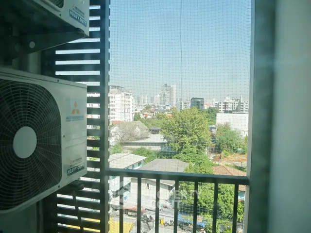 City view from balcony with air conditioning unit and urban skyline