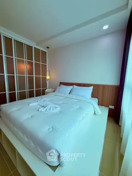 Spacious bedroom with modern design and ample natural light, featuring a large bed and stylish decor.
