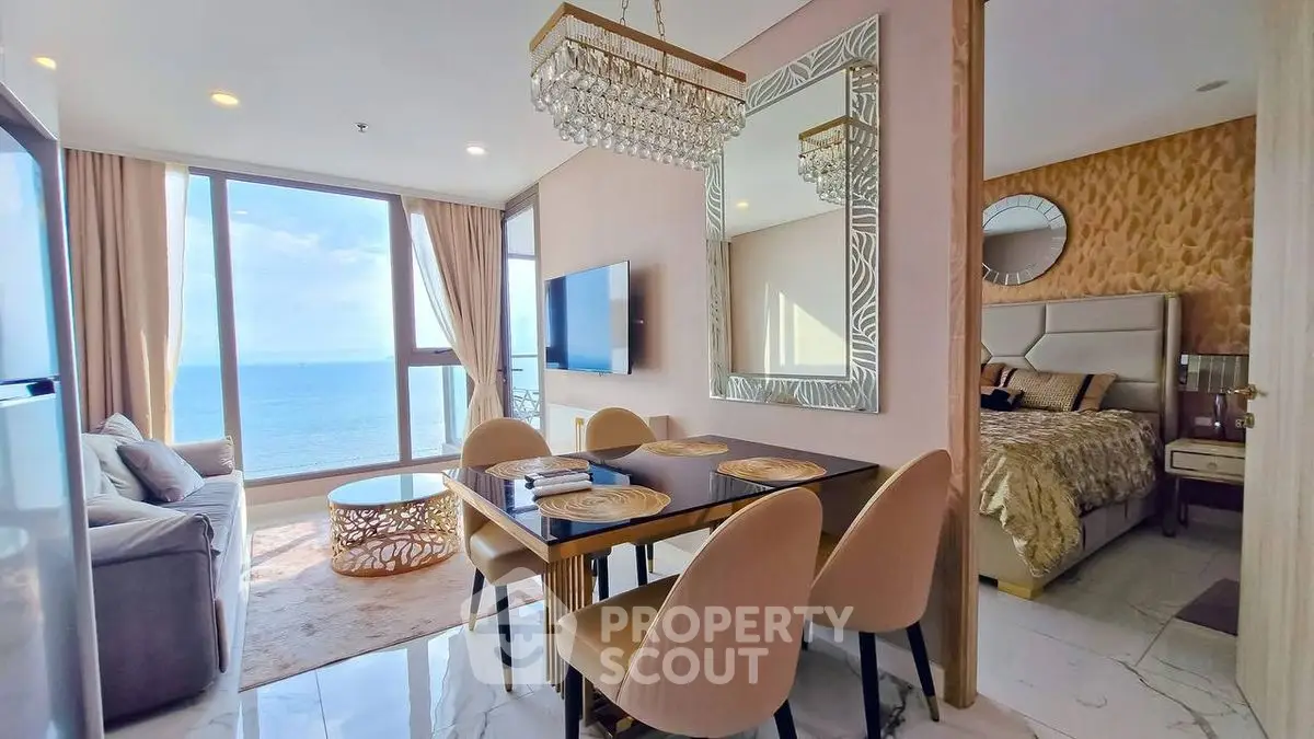 Luxurious beachfront apartment with stunning ocean view, elegant dining area, and cozy bedroom.