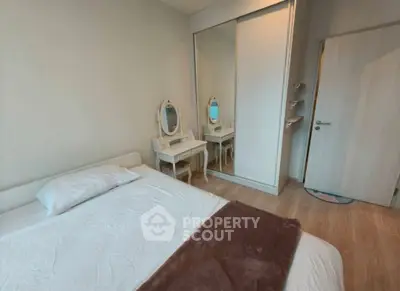 Cozy bedroom with elegant vanity and mirrored closet doors, perfect for relaxation.