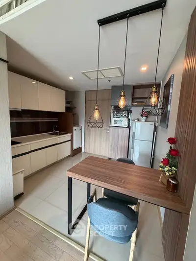 Modern kitchen with stylish lighting and open layout, featuring sleek cabinets and appliances.
