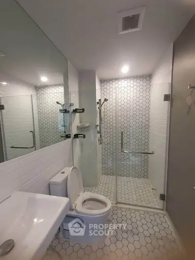 Modern bathroom with glass shower and hexagonal tile flooring