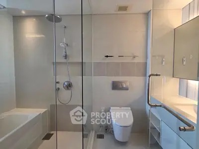 Modern bathroom with glass shower, bathtub, and sleek fixtures