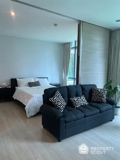 Spacious bedroom with stylish sofa and modern decor