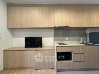 Modern kitchen with sleek wooden cabinetry and built-in appliances, perfect for contemporary living.