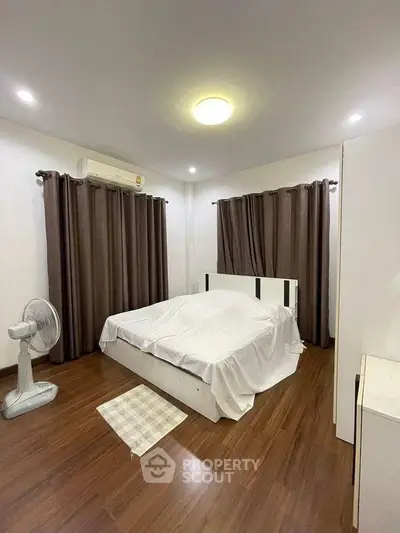 Cozy bedroom with wooden flooring and modern furnishings