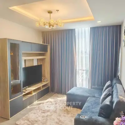 Modern living room with stylish furniture and large window offering natural light.