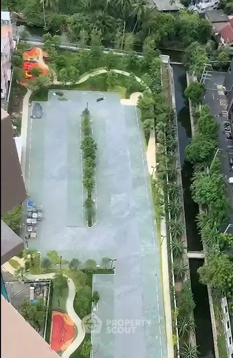 Aerial view of a residential complex with lush gardens and sports courts.